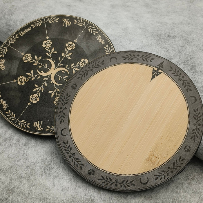 Two round bamboo pendulum boards with decorative black patterns on a gray