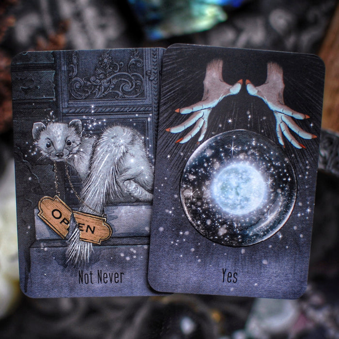Two tarot cards with mystical illustrations and text on a blurred background