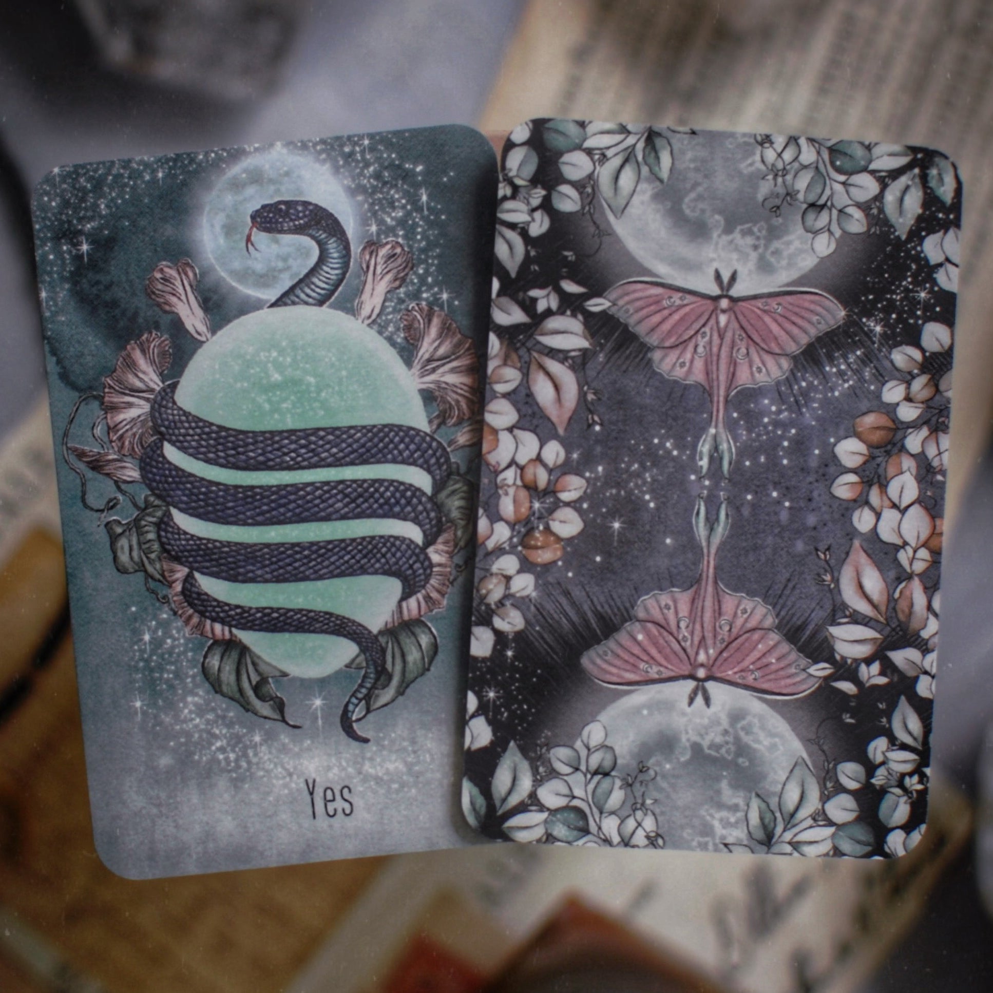 Two tarot cards with mystical designs on a textured surface.