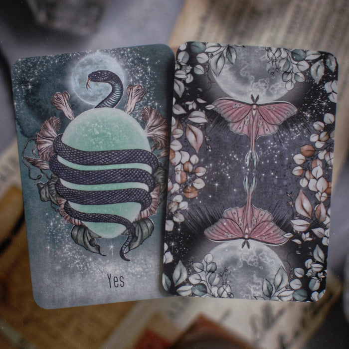 Two tarot cards with mystical designs on a textured surface.